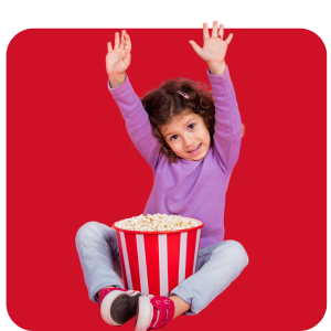 South Texas Cub Scout girl eating popcorn with hands raised.