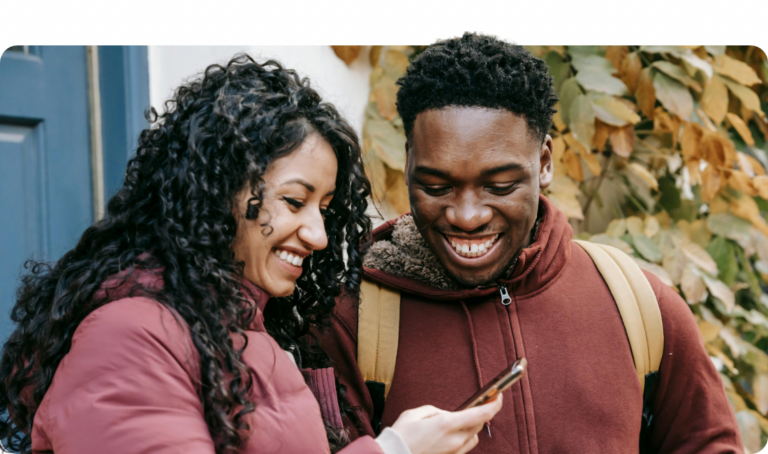 man and woman smiling at phone.