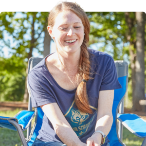 Cub scout mom sitting down laughing