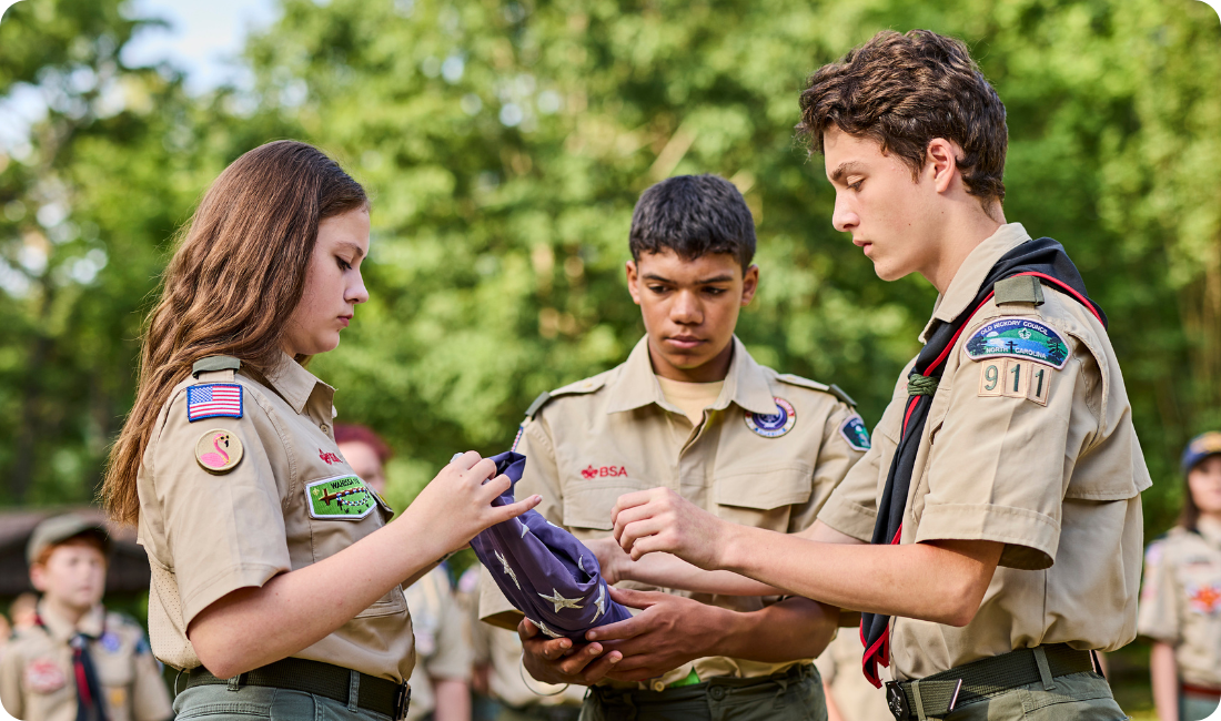 Scouts bsa boys and girls folding flag together